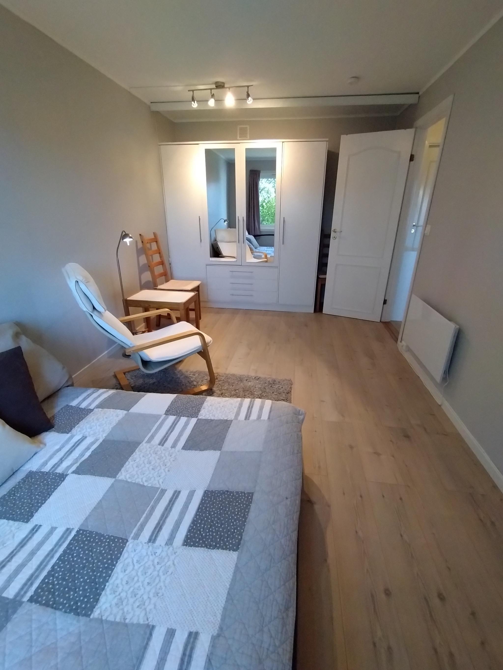 Stort rom sett fra vinduet. Stort klesskap i bakgrunnen.